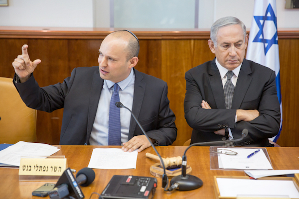 Israeli Prime Minister Benjamin Netanyahu crosses his arms as Education Minister Naftali Bennett speaks at a cabinet meeting, August 30, 2016. (Emil Salman/Pool)