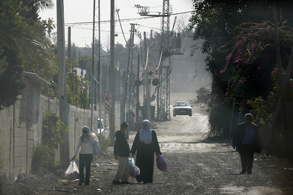Palestinian citizens of Israel carry their shopping to the ‘unrecognized’ neighborhood of Dahmash, in between the mixed cities of Ramla and Los. (Michal Fattal/Flash90)