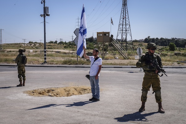 Israeli soldiers and pedestrians stand still at the Gush Etzion Junction, West Bank, as a two-minute siren is sounded across Israel to mark Holocaust Remembrance Day, May 5, 2016. (Gershon Elinson/Flash90)