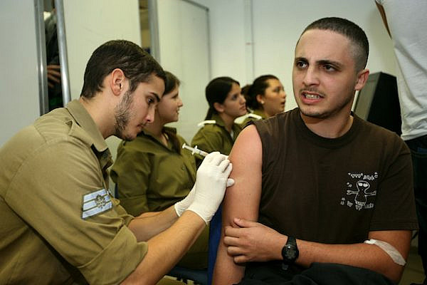 Illustrative photo of an Israeli recruit receiving a painful vaccine injection on his first day of military service. November 23, 2008. (Moshe Shai/Flash90)