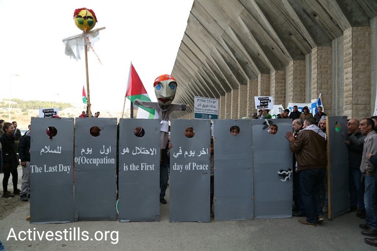 Palestinians and Israelis demonstrate next to the separation wall along Route 60, West Bank, December 16, 2016. (Keren Manor/Activestills)