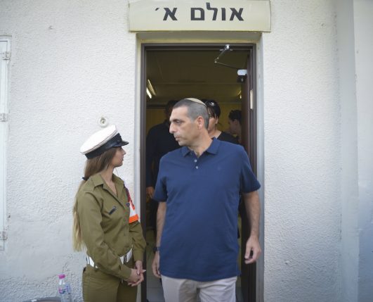 Ofek Buchris passes a young military policewoman as he leaves the Jaffa Military Court, September 29, 2016. (Flash90)