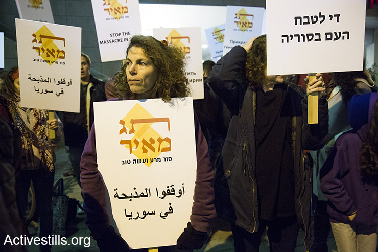 Protesters hold signs in English, Arabic, Hebrew and Russian calling to stop the massacre in Syria, Tel Aviv, December 18, 2016. (Keren Manor/Activestills)