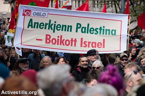 A banner of the Norwegian Confederation of Trade Unions (LO) reads, "Recognize Palestine, Boycott Israel" as thousands of Norwegians march through Oslo city streets in a May Day parade, May 1, 2016. (Ryan Rodrick Beiler/Activestills.org)