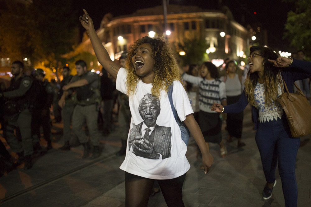 A young woman chants as she marches past police officers at an anti-racism and anti-police violence protest by Ethiopian activists in Israel, April 30, 2015. (Activestills.org)