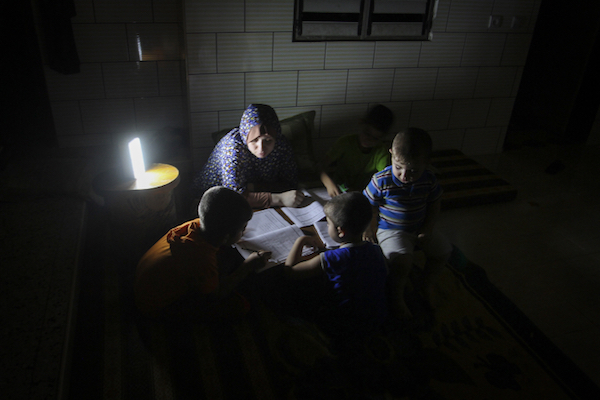 Palestinian students study next to a lantern during a power outage in Rafah, Gaza Strip, May 18, 2016. (Abed Rahim Khatib/Flash90)