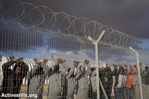 African asylum seekers jailed in the Holot detention center protest behind the prison's fence, February 17, 2014. (Photo by Activestills.org)