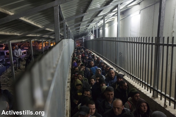 Palestinians laborers wait to pass through an Israeli military checkpoint leading from Bethlehem to Jerusalem, February 8, 2017. (Anne Paq/Activestills.org)