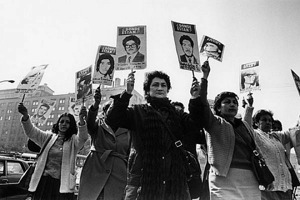 Women from the Association of the Families of the Disappeared demonstrate in front of the palace of the government during the military rule of Pinochet. By Museum of Memory and Human Rights. CC BY-SA 3.0.