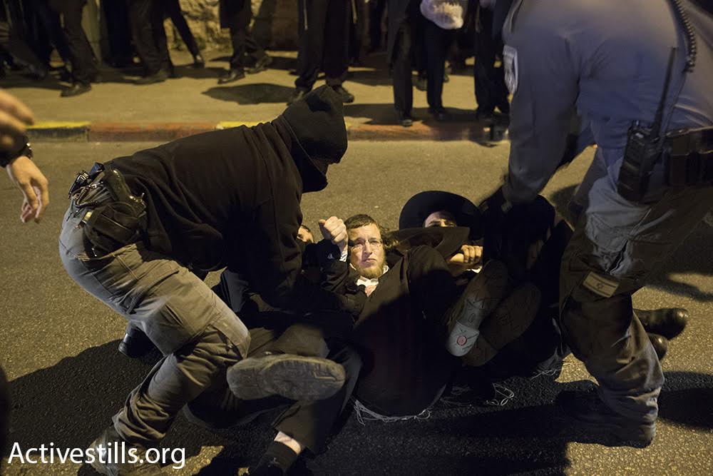 Police hold down ultra-Orthodox demonstrators during a protest against the arrest of an IDF deserter, Jerusalem, March 23, 2017. (Oren Ziv/Activestills.org)