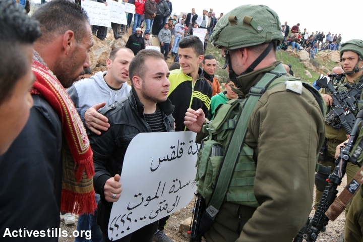 Palestinians take part in a protest against the Israeli military closure of the main entrance to Qalqas, near Hebron, which was imposed during the Second Intifada, West Bank, March 17, 2017. (Ahmad al-Bazz/Activestills.org)