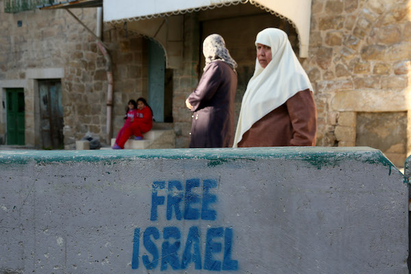 Palestinian woman walk on the segregated Shuhada Street, in the divided West Bank town of Hebron, January 15, 2013. (Nati Shohat/FLASH90)