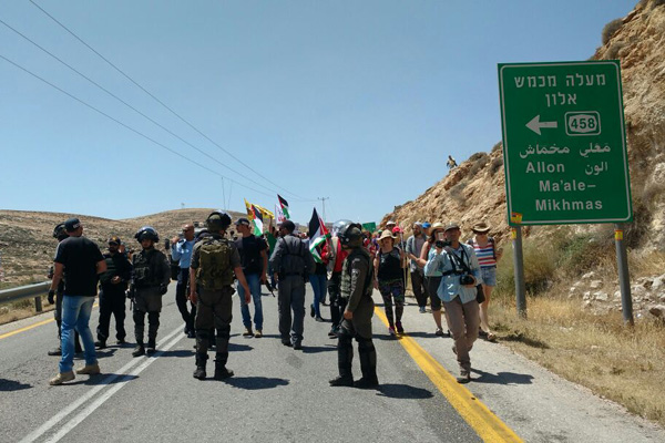 Israeli troops attempt to block anti-occupation activists from marching down a West Bank road toward a settlement in a protest against settler violence, April 28, 2017. (Orly Noy)