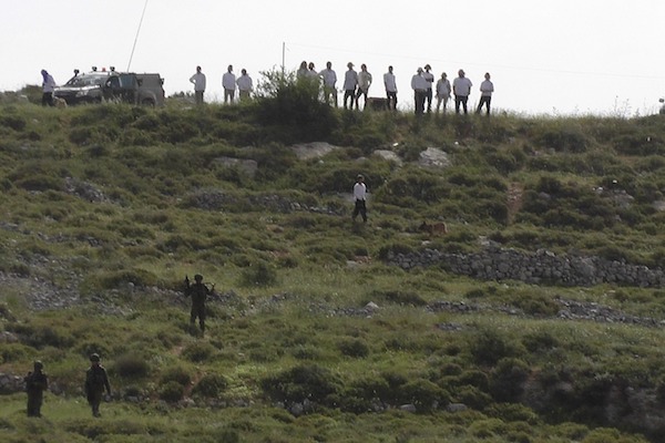 Settlers stand atop a hill near the Palestinian village of Urif, which was attacked twice on Saturday, April 22, 2017. (Urif Council)