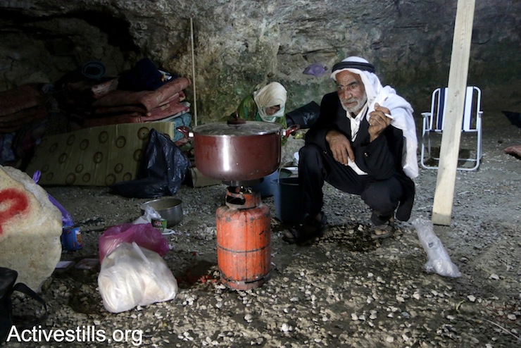 Fadel Al-Amer, a Palestinian elder from Sarura, prepares dinner in his cave which was rehabilitated by activists in order to bring people back to the village, May 24th, 2017. (Ahmad al-Bazz/Activestills.org)