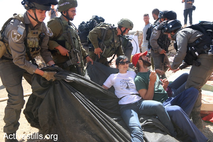 Palestinians, Israelis, and diaspora Jewish activists confront the Israeli army during a raid on Sumud Freedom Camp, Sarura, West Bank, May 25, 2017. (Ahmad al-Bazz/Activestills.org)