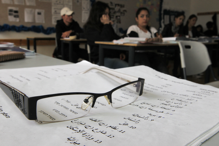 A pair of glasses resting on a worksheet used to teach Arabic to Israeli students, during an Arabic class at the Branco Weiss School. (Flash90)