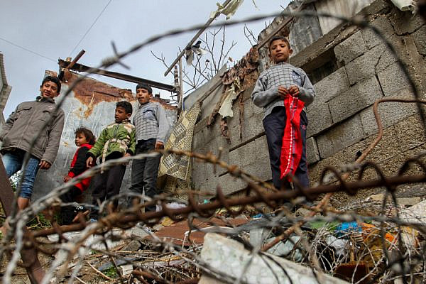 Palestinian kids seen at the entrance to a house in a flooded area following heavy rainfall, in Rafah, in the southern Gaza Strip, on February 15, 2017. (Abed Rahim Khatib/Flash90)