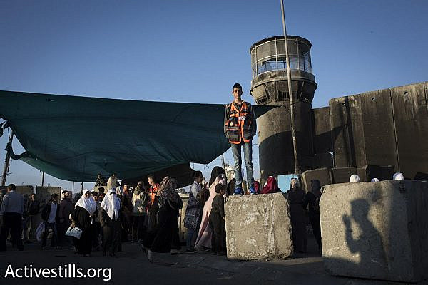 Palestinian women and children, along with men over the age of 40, walk through Qalandiya checkpoint toward Jerusalem on the first Friday of Ramadan, June 2, 2017. (Oren Ziv/Activestills.org)