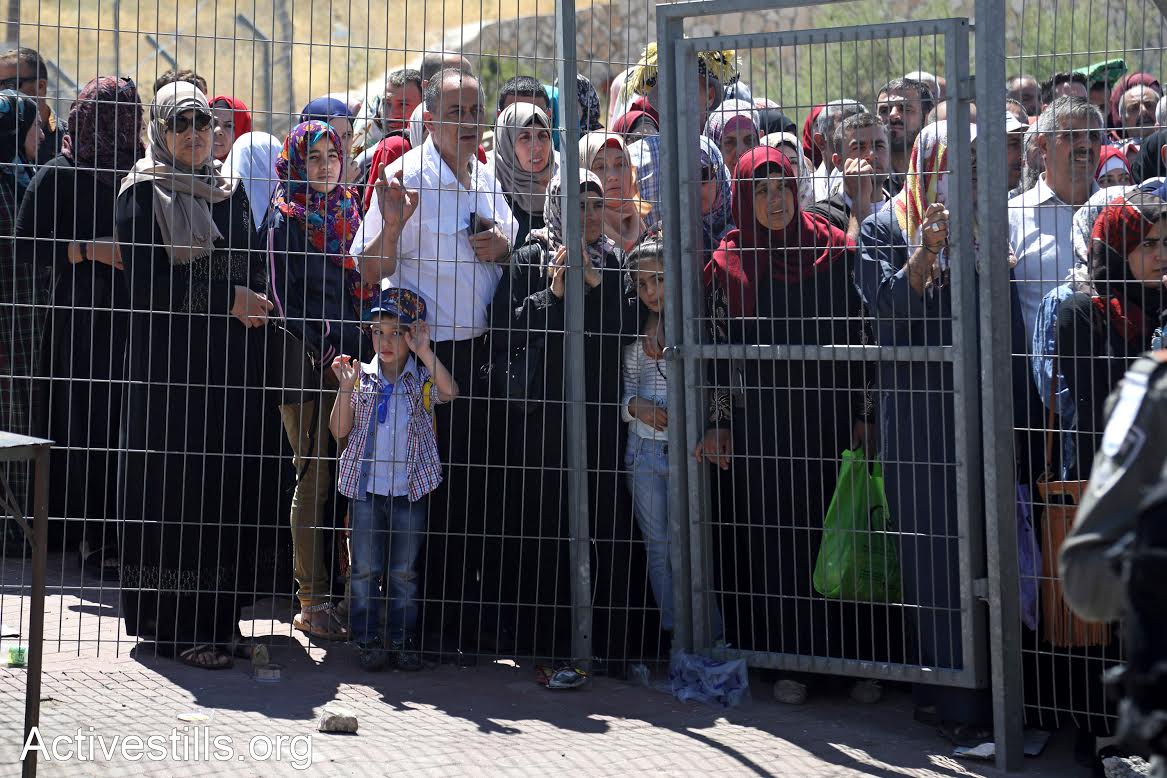 Palestinians wait in line at Checkpoint 300 outside Bethlehem on the last Friday of Ramadan, July 23, 2017. (Haidi Motola/Activestills.org)