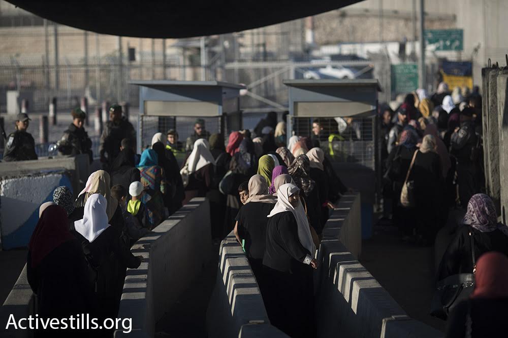 Palestinian women cross Qalandiya checkpoint into Jerusalem's A-Ram neighborhood during the first Friday of Ramadan. The Israeli authorities limited crossing to women, children, and men over the age of 40. (Oren Ziv/Activestills.org)
