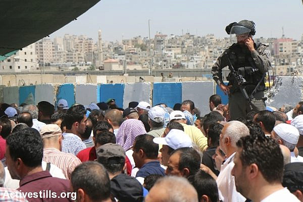 Palestinians from the West Bank cross through Qalandyia checkpoint to attend the second Friday prayers in Jerusalem's Al-Aqsa Mosque, June 9, 2017. Israeli authorities allowed women of all ages and men over 40 to enter Jerusalem without permits on Fridays during the month of Ramadan only. (Ahmad al-Bazz/Activestills.org)