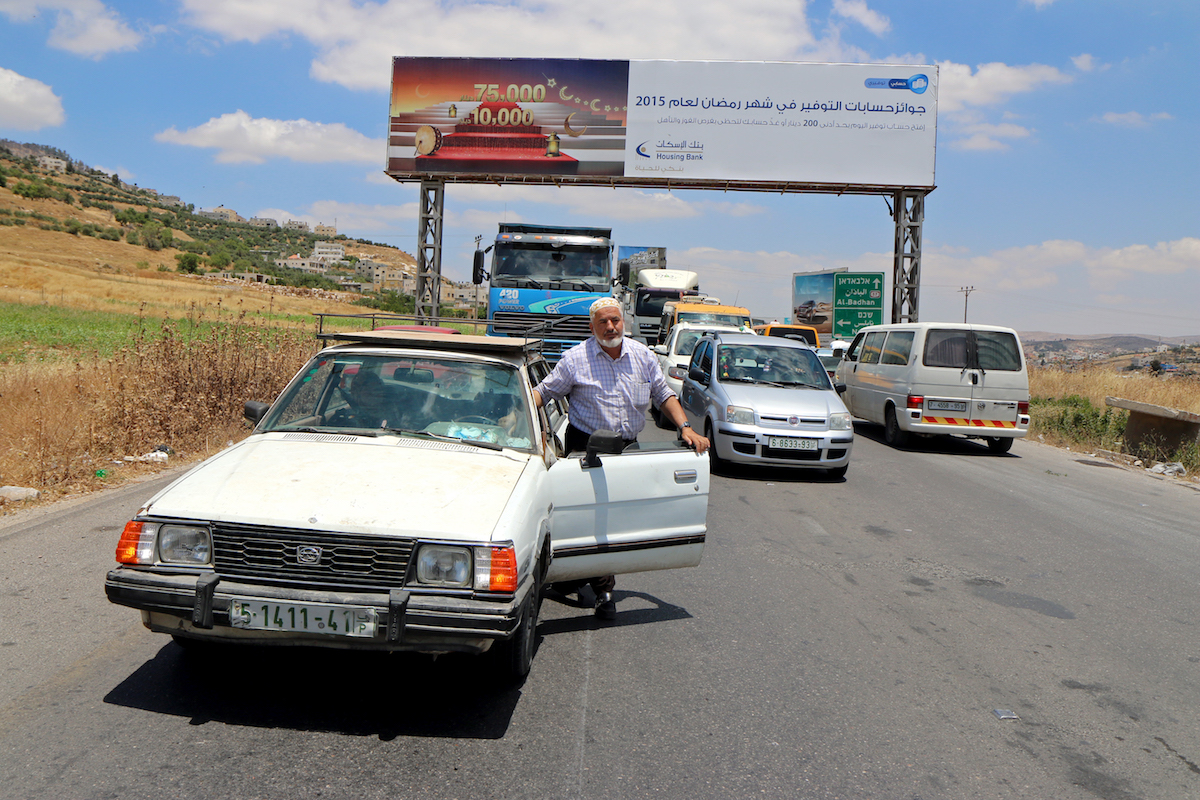 Palestinians wait as Israeli soldiers shut down the Huwwara checkpoint, the main entrance of Nablus. (Ahmad Al-Bazz/Activestills.org)