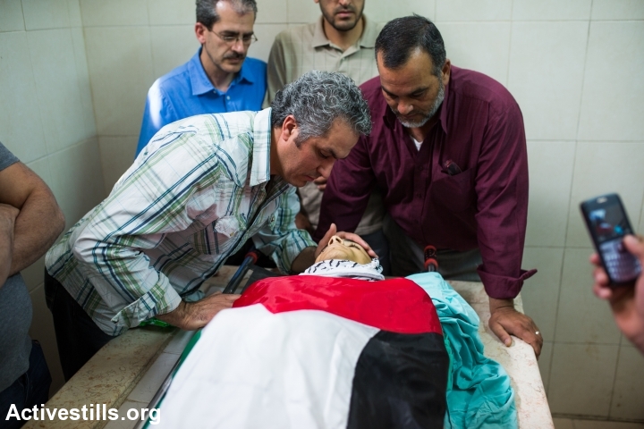 The father of Nadeem Seeam Nowarah mourns over his son before his funeral procession in the West Bank city of Ramallah on May 16, 2014. (Yotam Ronen/Activestills.org)