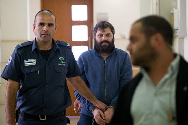 Prison guards escort Yosef Haim Ben-David, the third defendant in the murder of Muhammed Abu Khdeir, arrives to the Disctrict Court in Jerusalem, on April 5, 2016. Abu Khdeir, 16, a Palestinian teenager was abducted and killed in Jerusalem more then a year ago. His murder sparked violent protests in Arab areas of Jerusalem and northern Israel. (Yonatan Sindel/Flash90)