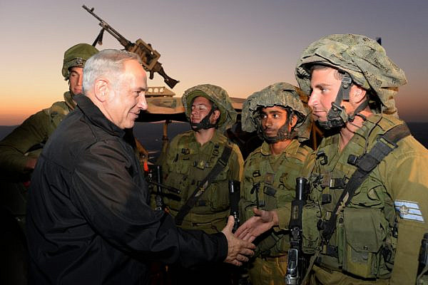 Prime Minister Benjamin Netanyahu seen with Israeli soldiers of the IDF Armored Corps during an army exercise in the Golan Heights, northern israel on October 15, 2013. (Kobi Gideon/GPO)
