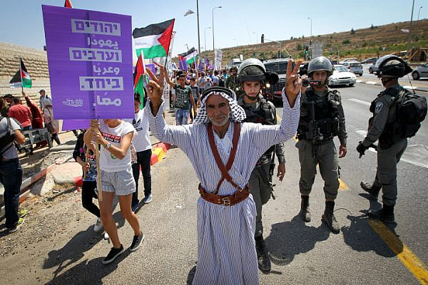 Palestinian and Israeli activists take part a protest against occupation, Route 60, between Jerusalem and the West Bank city of Bethlehem, July 7, 2017. (Wisam Hashlamoun/Flash90)