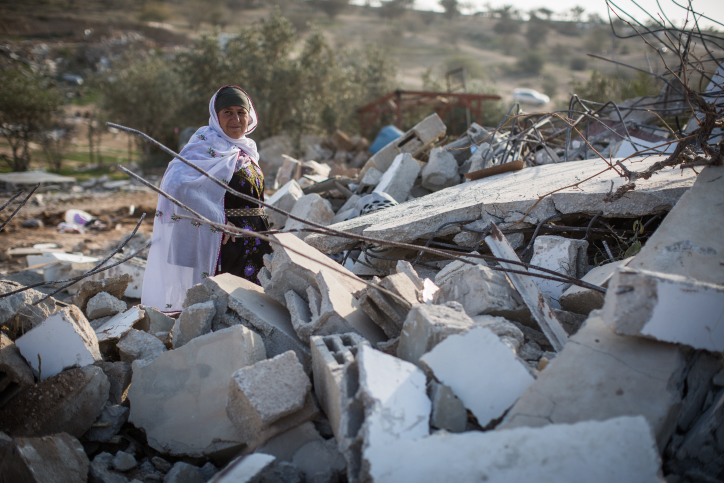 Bedouins collect their belongings from the ruins of their demolished homes in the Bedouin village of Umm al-Hiran, January 18, 2017. (Hadas Parush/Flash90)