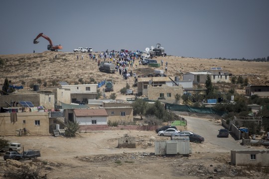 Hundreds of Bedouin residents and supporters march toward a bulldozer in the village of Umm al-Hiran, in a protest against the plan to establish a new Jewish town on its ruins, August 27, 2015. (Hadas Parush/Flash90)