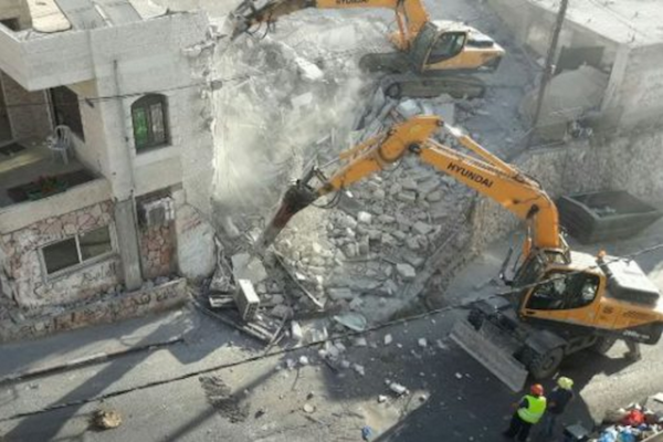 An Israeli bulldozer demolishes homes in the East Jerusalem neighborhood of Issawiya, August 15, 2017.