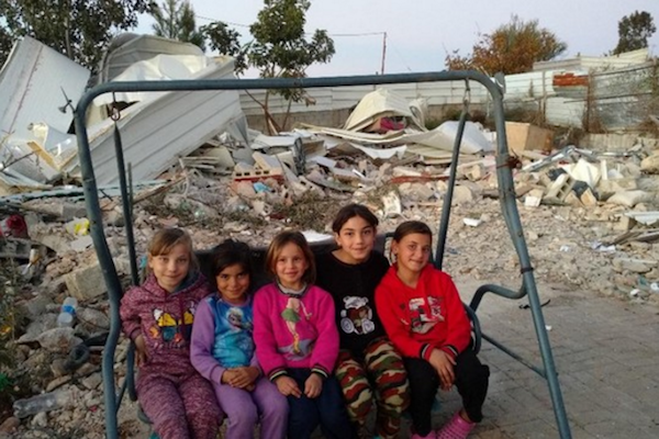 Issam Rajbi's children sit in front of the ruins of their home, Beit Hanina, East Jerusalem. 