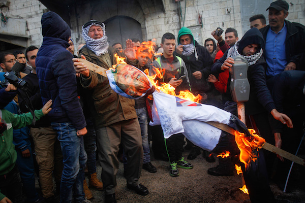 Palestinian burns the doll a poster depicting U.S. President Donald Trump during a protest against US President Donald Trump's announcement that he recognized Jerusalem as the capital of Israel, in the West Bank city of Nablus, on December 7, 2017. (Nasser Ishtayeh/Flash90)