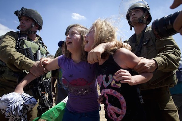 Israel soldiers grab Ahed Tamimi and a relative as she is being arrested at the entrance to Nabi Saleh's water spring, during the weekly protest against the occupation in the West Bank village, August 24, 2012. (Activestills)