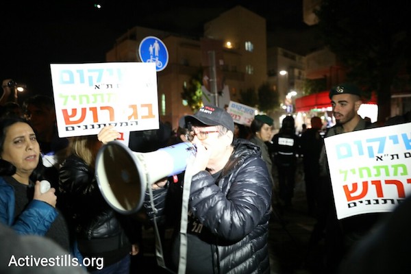 Holding signs reading 'The rehabilitation of south Tel Aviv begins with deportation,' residents of south Tel Aviv stage a counter-protest to a demonstration in support of refugees and against their impending deportation, Tel Aviv, January 9, 2017. (Oren Ziv/Activestills.org)