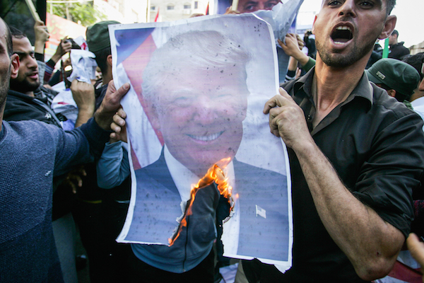 Palestinian burning a picture of US President Donald Trump during a protest against US President Donald Trump's latest decision to recognized Jerusalem as the capital of Israel, in Rafah, in the Southern Gaza Strip on December 8, 2017. (Abed Rahim Khatib/Flash90)