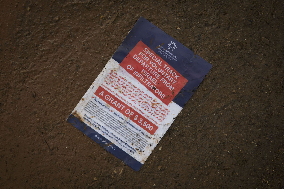 A flyer passed out to Eritrean and Sudanese asylum seekers by Israeli immigration authorities is seen outside the Interior Ministry office in Bnei Brak, Israel, in mid-February 2018. (Oren Ziv/Activestills.org)