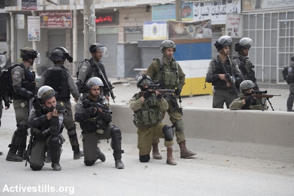 Israeli snipers prepare to shoot at Palestinian youth, during clashes of Israeli forces with Palestinian protesters in Qalandiya checkpoint, near the West Bank town of Ramallah, December 20, 2017. (Oren Ziv/Activestills.org)