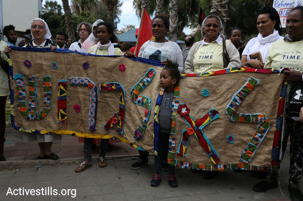 Asylum seekers hold up an embroidery reading 'No to deportation' during a women's march in support of asylum seekers, south Tel Aviv, March 9, 2018. (Oren Ziv/Activestills.org)