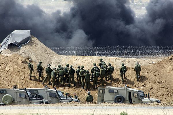 Palestinian protesters demonstrate and burn tires near the border with Israel in the Gaza Strip, as seen from the Israeli side of the border, April 13, 2018. (Sliman Khader/Flash90)