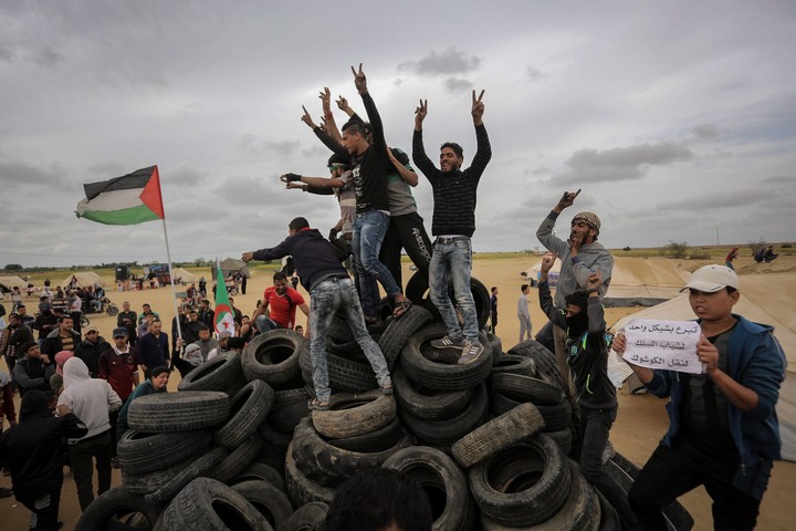Palestinians youth collect tires to burn them during demonstrations in Khan Yunis, southern Gaza Strip, April 4, 2018. (Abed Rahim Khatib/Flash90)