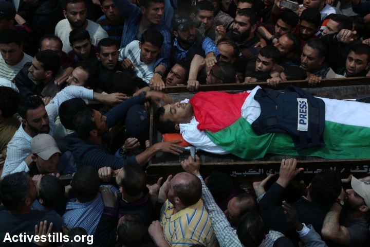 Mourners and fellow journalists carry the body of Yasser Murtaja at his funeral in Gaza City, April 7, 2018. Murtaja was shot and killed by Israeli soldiers during the Great Return March in the southern Gaza Strip. (Mohammed Zaanoun/Activestills.org)