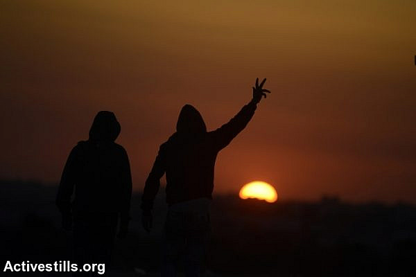 Palestinians seen at sunset during a protest as part of the Great Return March, near the Israeli-Gaza fence, eastern of Jabaliya refugee camp, Gaza Strip, April 23, 2018. (Mohammed Zaanoun/Activestills.org)