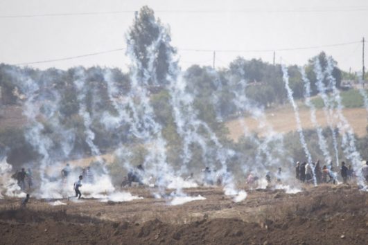 Gaza protesters run from tear gas and live ammunition during Friday's Great Return March demonstrations. May 11, 2018. (Oren Ziv / Activestills.org)
