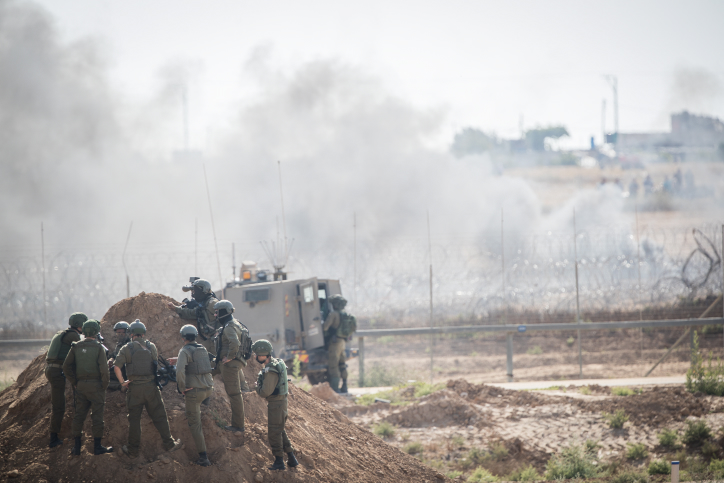 Israeli soldiers shoot tear gas is shot at Palestinian protesters on the border with the Gaza Strip, as Palestinians demonstrate to mark Naksa Day, June 8, 2018. (Yonatan Sindel/Flash90)