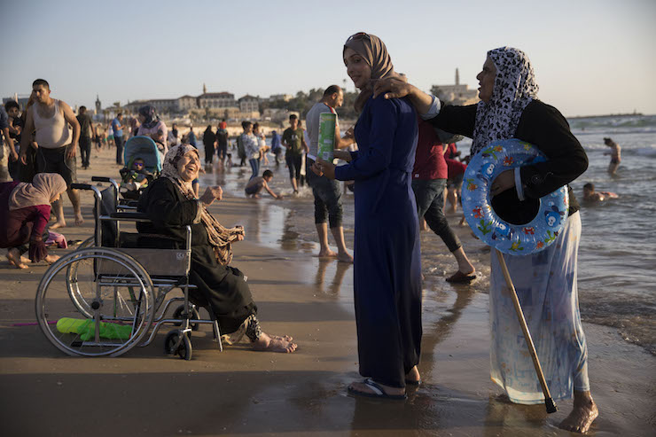 Palestinians from the West Bank enjoy the beach in Tel Aviv- Jaffa during the Eid al-Fitr holiday. June 17, 2018. (Oren Ziv/Activestills.org)