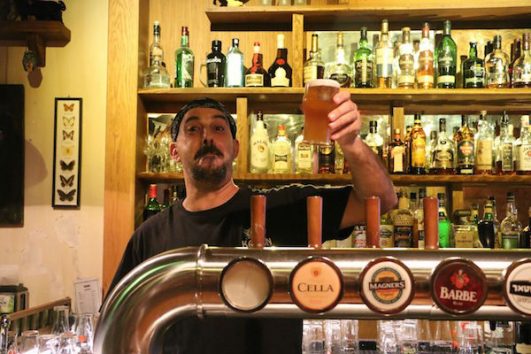 Samim Bishara raises a glass from behind the bar at Kamun Pub. (Steven Davidson)